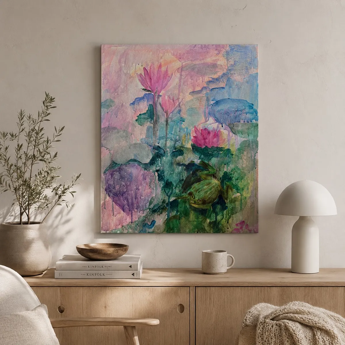 Whispers of the Pond hung unframed on a soft plaster wall above a wooden console with olive branches and a ceramic mushroom-shaped lamp